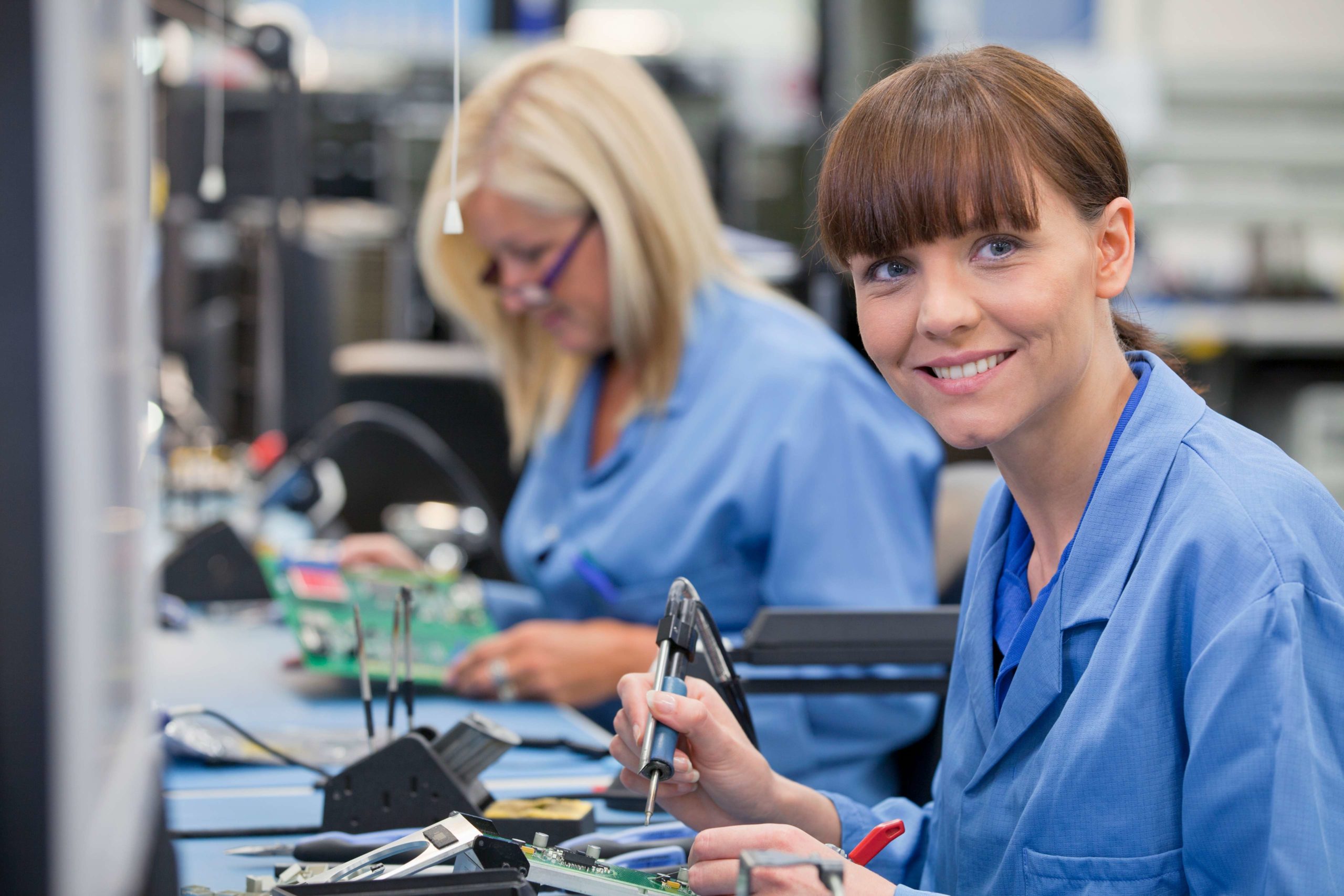 two women electrical engineers working on electrical parts in a factory 