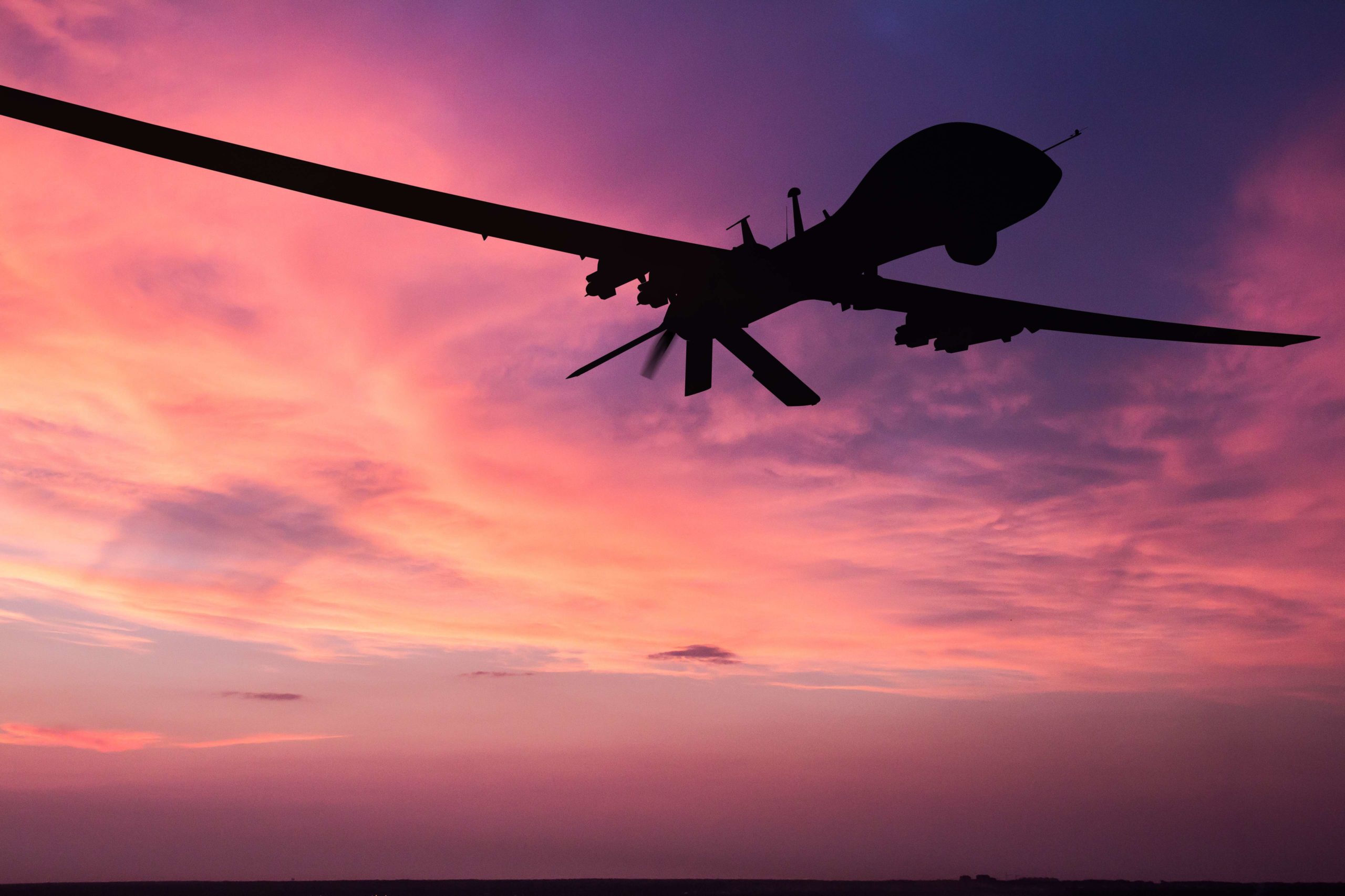 a silhouette of an aircraft on a pink sky